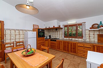 A kitchen with wooden cabinets and a white refrigerator
