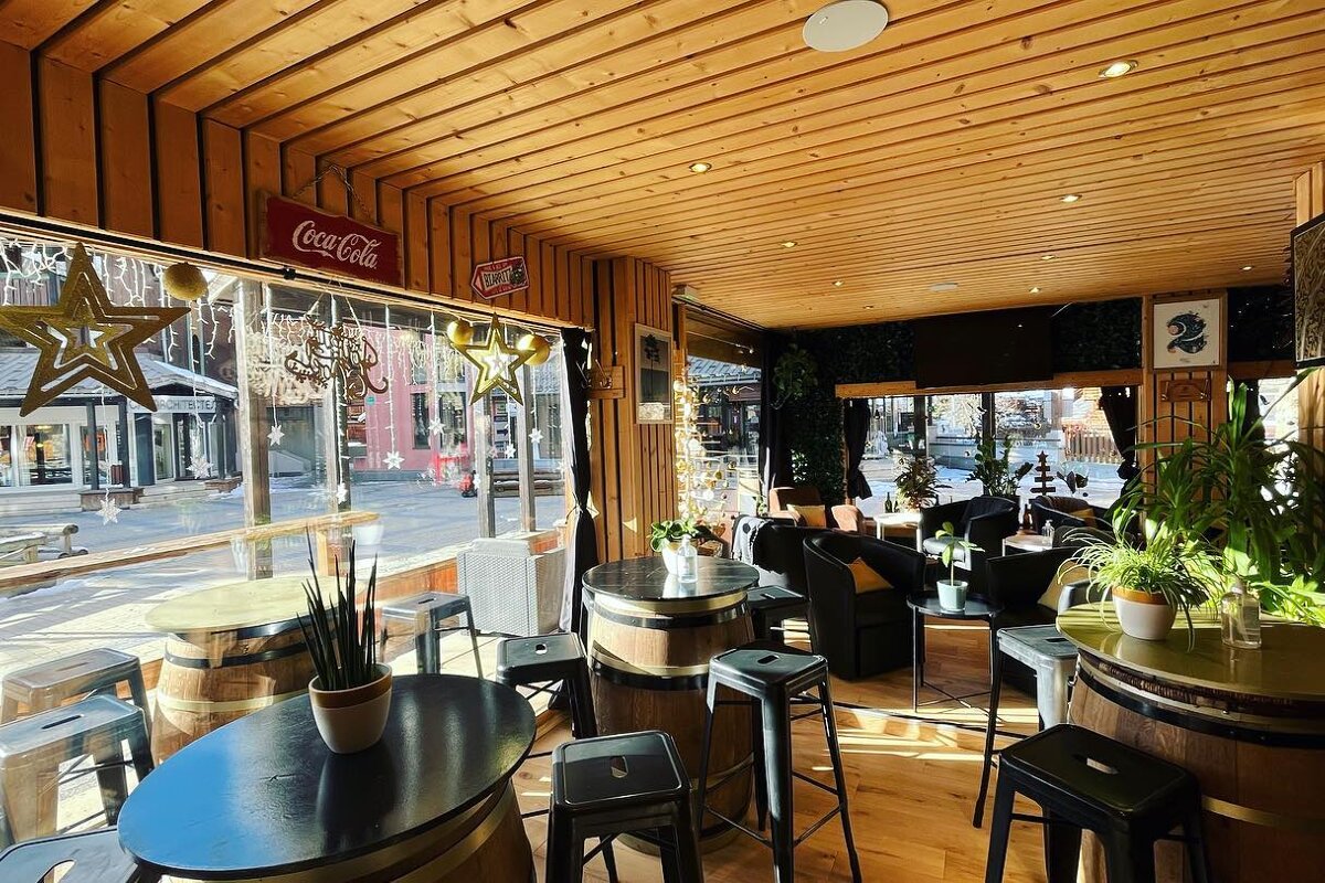 A coca cola sign hangs from the ceiling of a restaurant