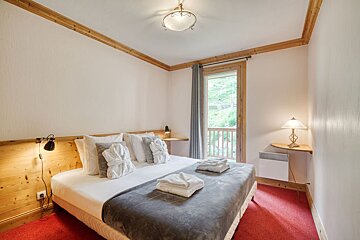 A bedroom with a large bed and a window