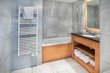 A bathroom with a bathtub and a towel rack