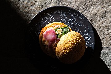 A black plate with a bunch of food on it