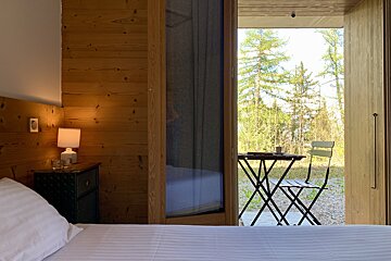 A bedroom with a table and chairs in front of a window