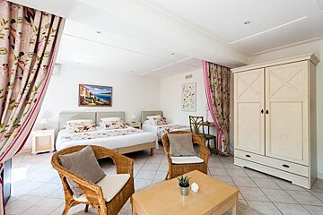 A bedroom with two beds and a painting on the wall