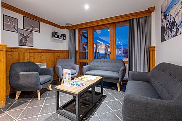 A living room with a couch and two chairs