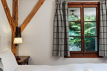 A bedroom with a bed and a window with curtains