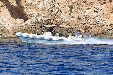 A boat with a canopy on the top of it is floating on the water