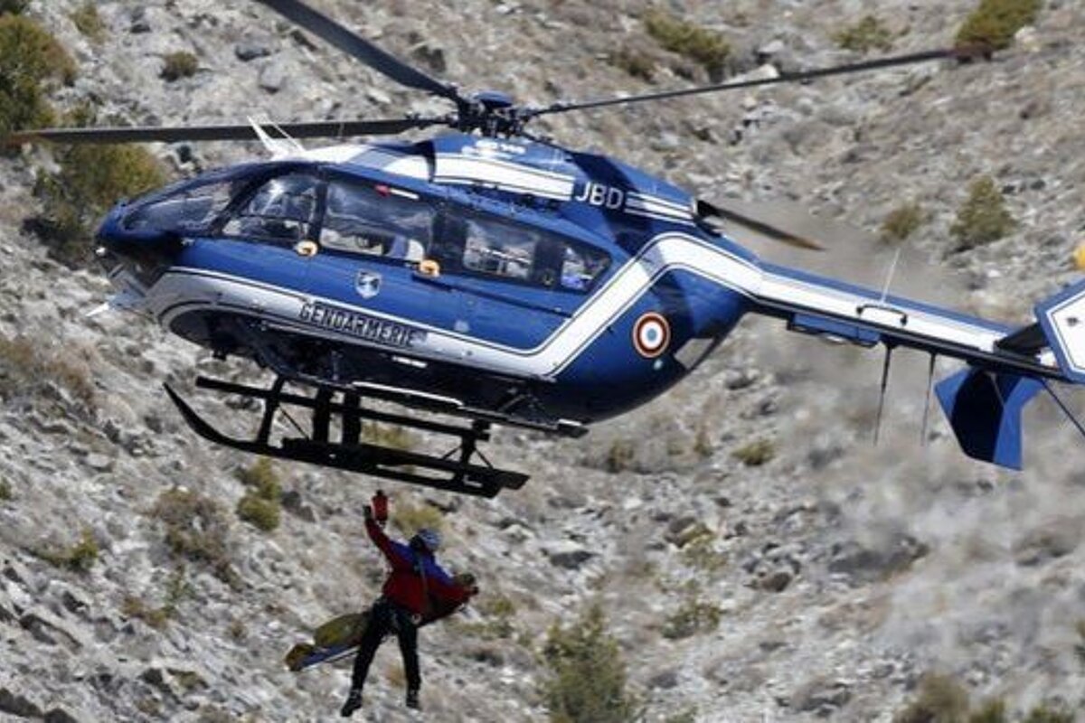 helicopter with man dangling off it