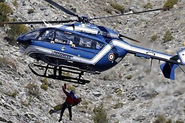 helicopter with man dangling off it