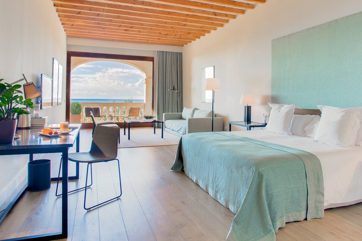 A hotel room with a large bed and a desk