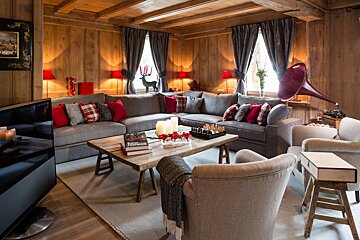 A living room with a large sectional couch and a book titled footloose