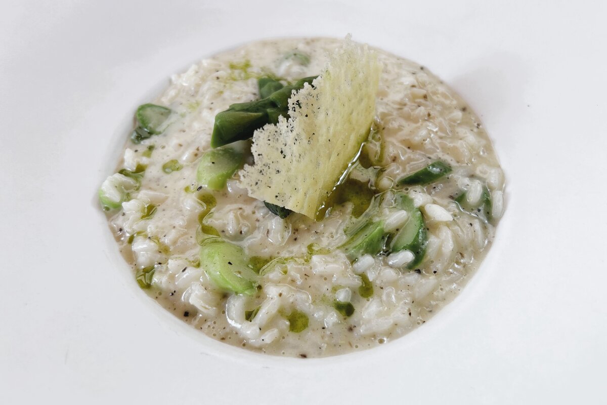 A bowl of rice with asparagus and cheese on top
