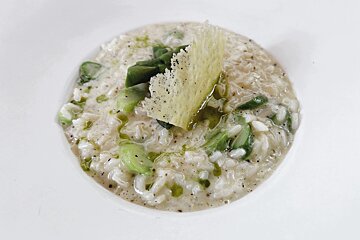 A bowl of rice with asparagus and cheese on top
