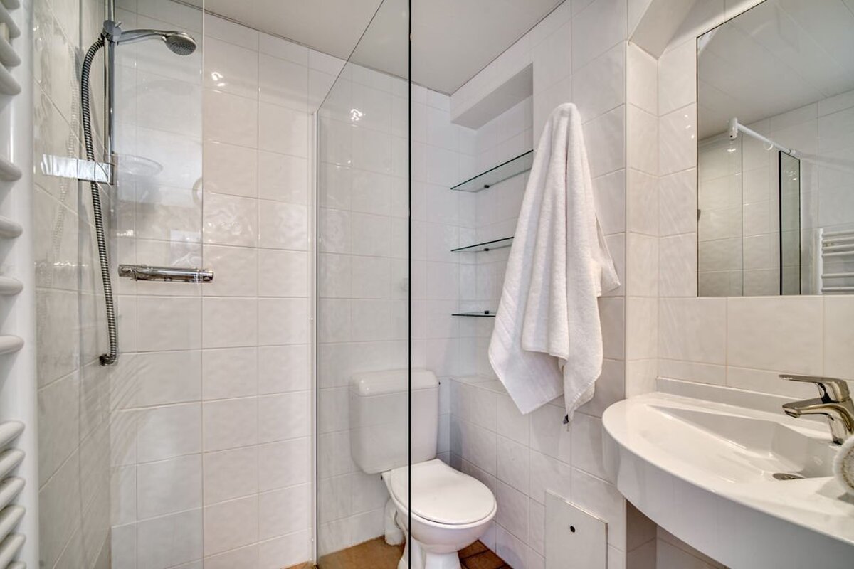 A bathroom with a toilet a sink and a shower