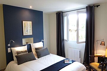 A bedroom with a bed and a book on the bed