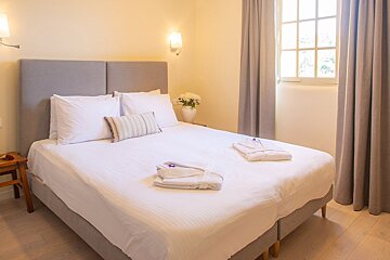 A bedroom with a large bed and a window