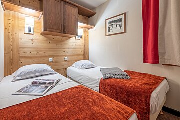 A bedroom with two beds and a picture on the wall