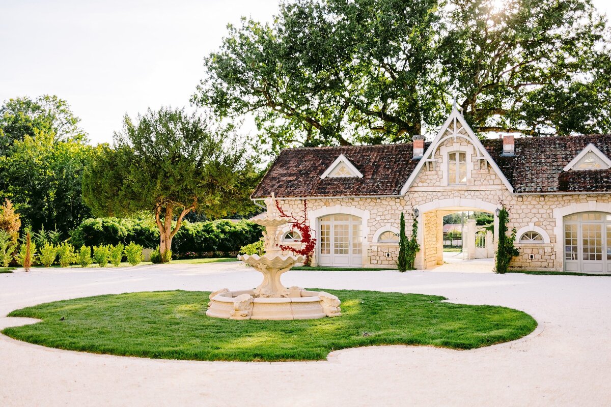 A white house with a fountain in front of it