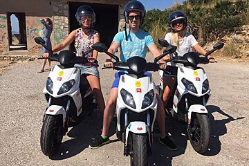 three moped riders with helmets on