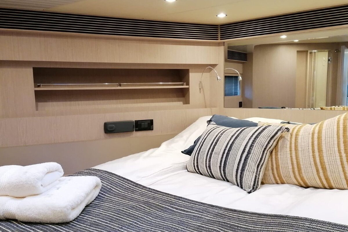 A bed with a striped pillow and towels on it