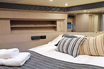 A bed with a striped pillow and towels on it