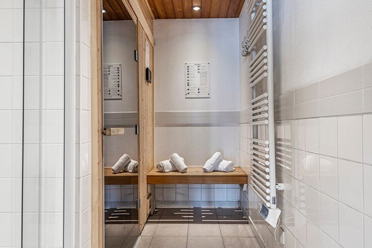 A bathroom with towels on a bench and a towel rack