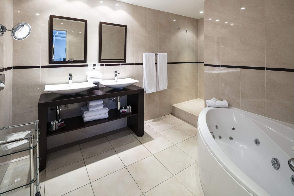 A bathroom with two sinks and a jacuzzi tub