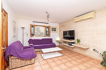 A living room with a purple couch and a flat screen tv