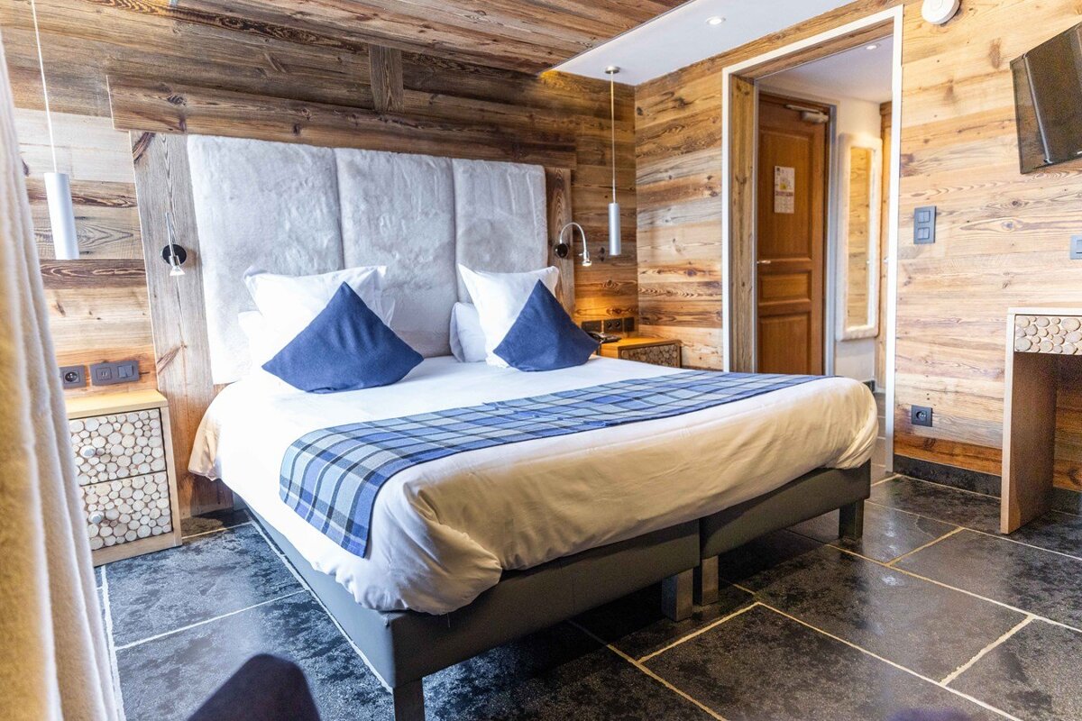 A hotel room with a large bed and wooden walls
