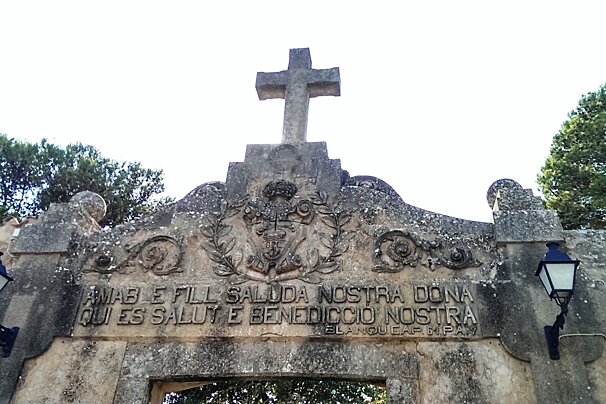 the entrance to a monastery with a big stone cross