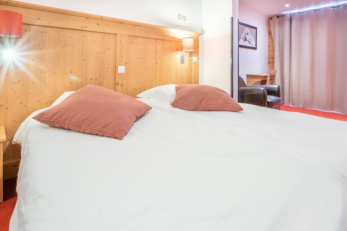 A hotel room with a bed and a chair