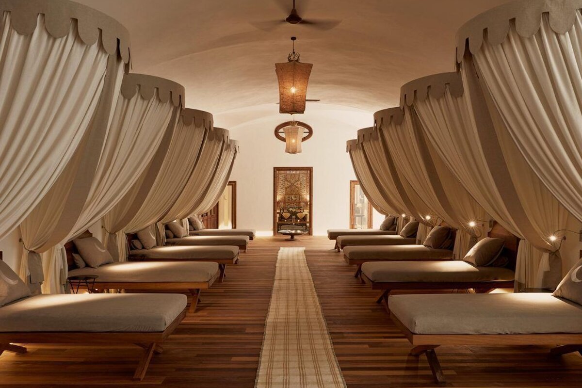 A room with a lot of beds and curtains