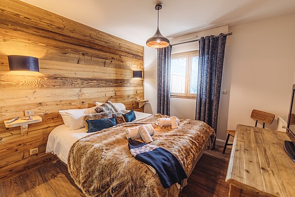 A bedroom with a bed and a wooden wall