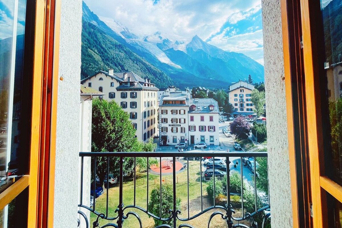 A balcony with a view of a city and mountains