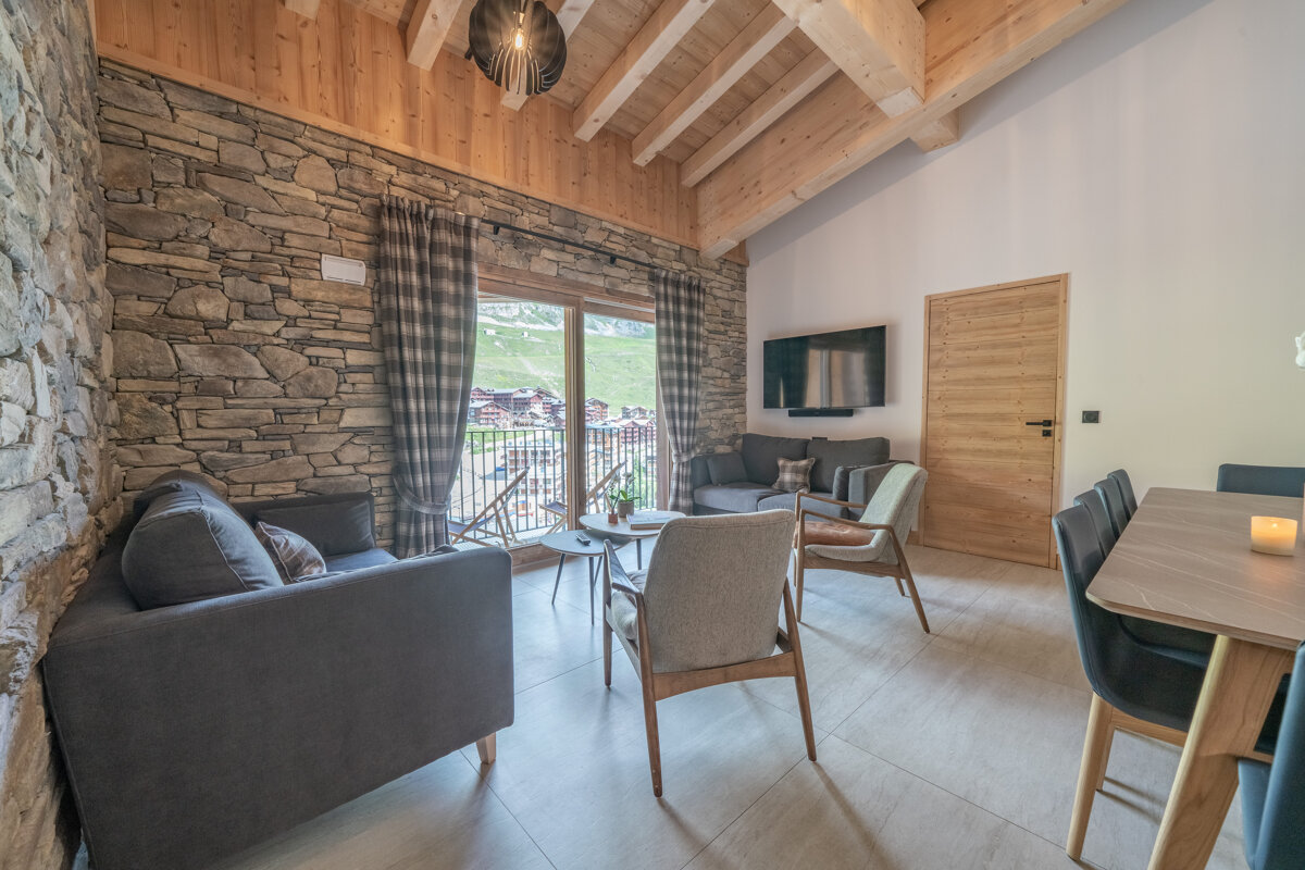 A living room with a stone wall and wooden beams
