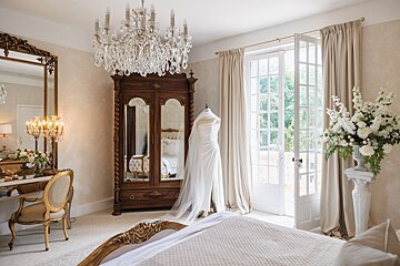 A bedroom with a dress on a mannequin and a chandelier