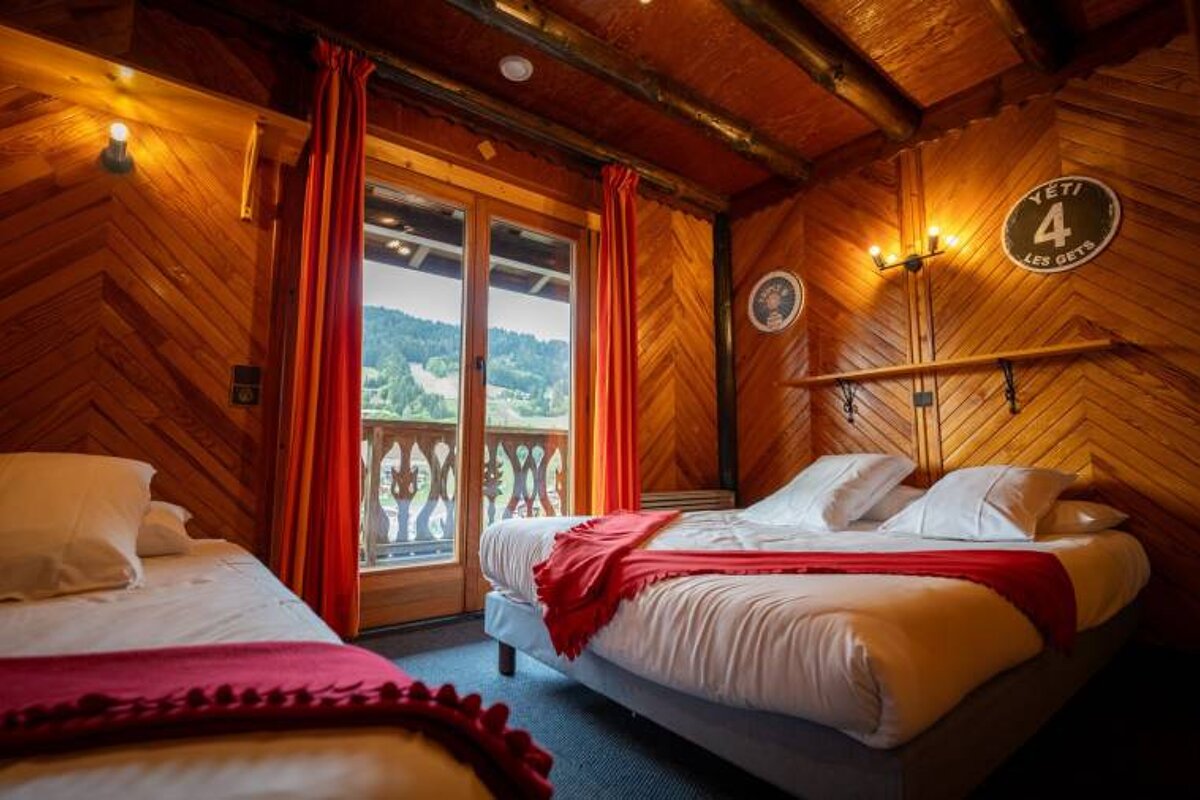 A bedroom with two beds and a sign that says yeti