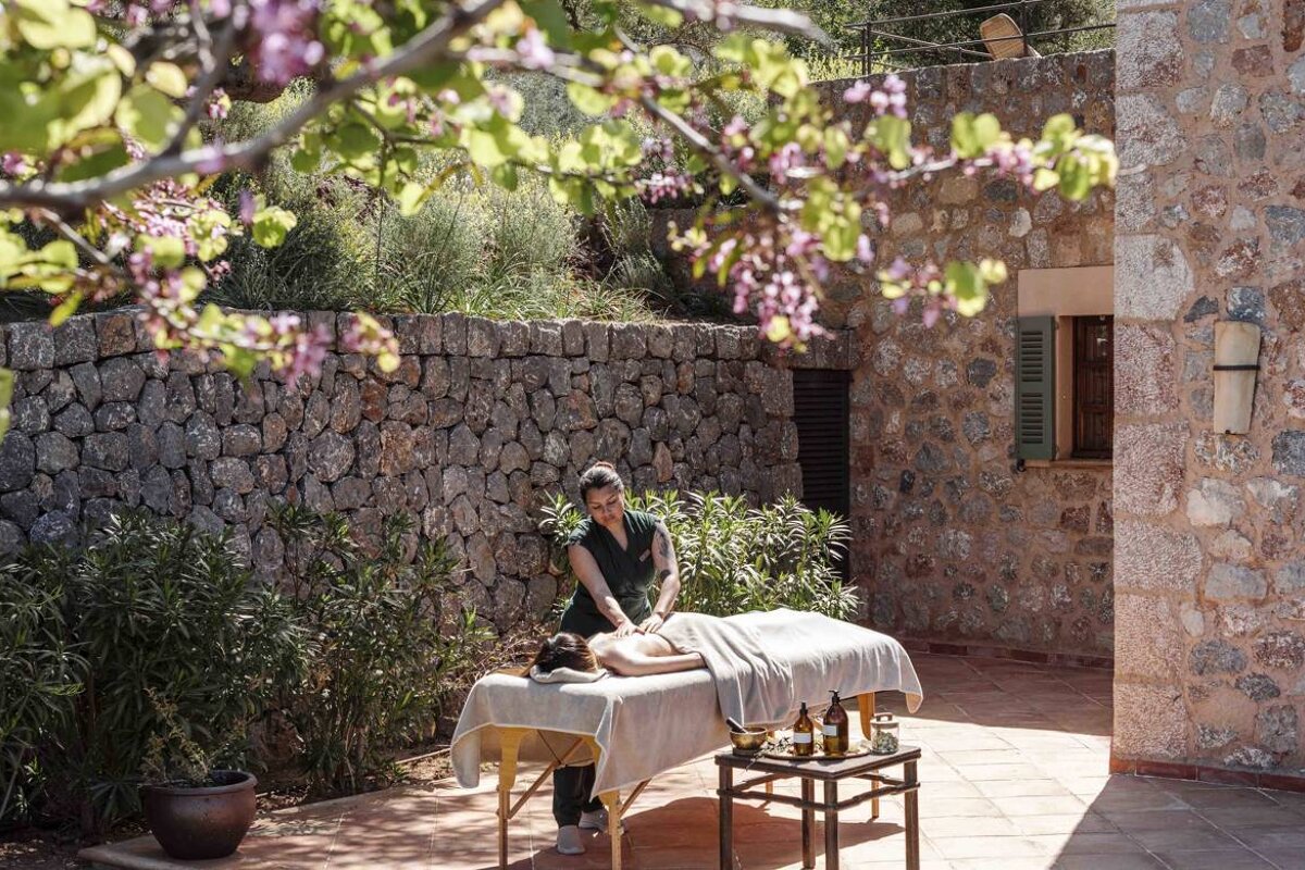 A woman is giving a man a massage on a table outside
