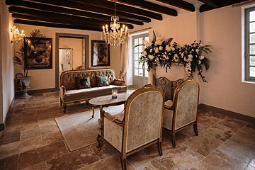 A living room with a couch and chairs and a chandelier