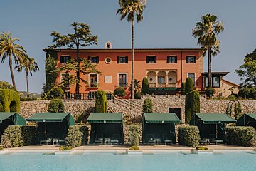 A large building with a swimming pool in front of it