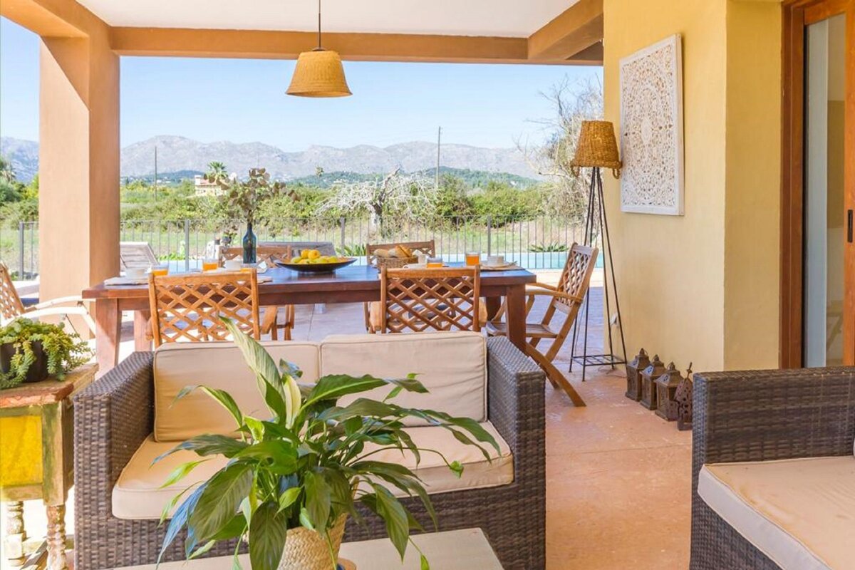 A table and chairs on a patio with mountains in the background