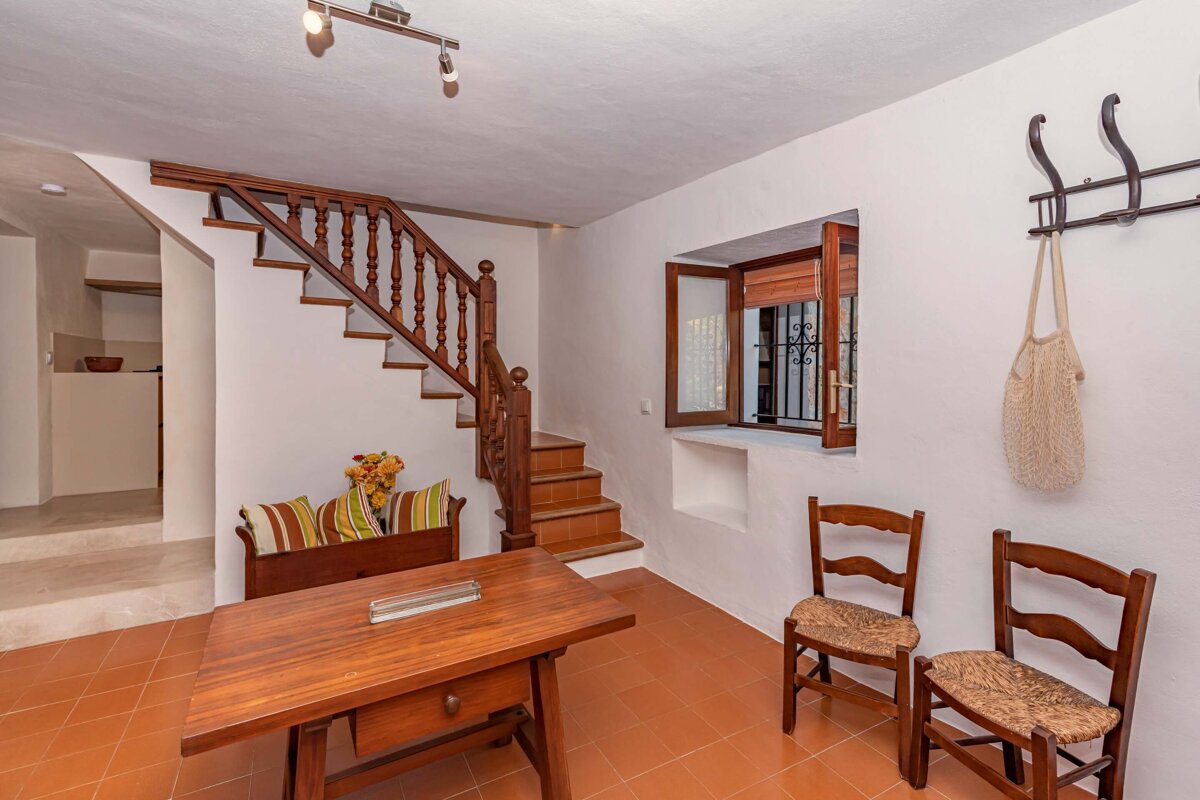 A wooden table and chairs in a room with stairs