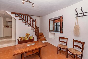 A wooden table and chairs in a room with stairs
