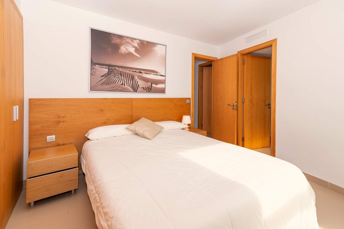 A bedroom with a bed and a picture on the wall