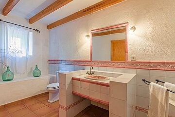A bathroom with a sink toilet and a mirror