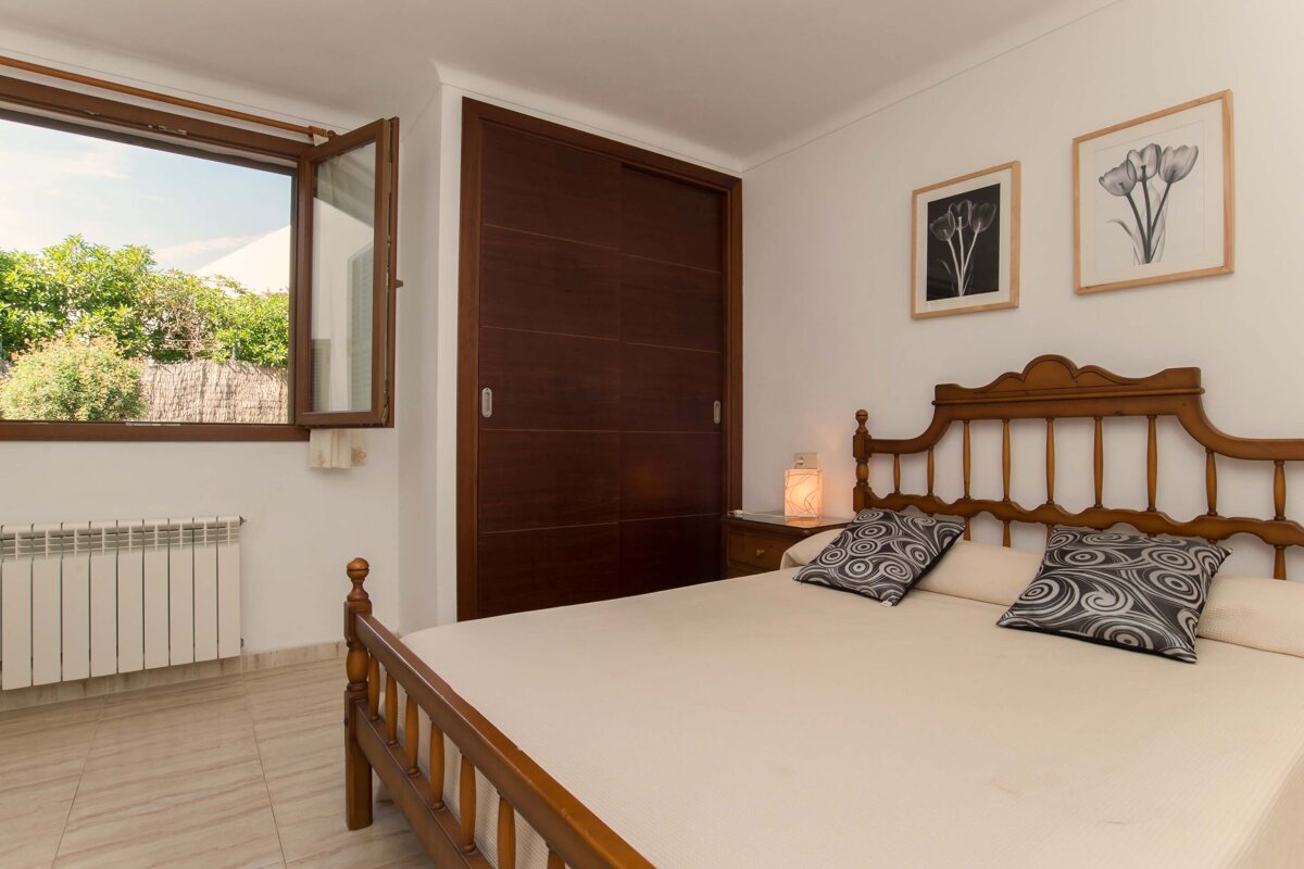 A bedroom with a bed and two pictures on the wall