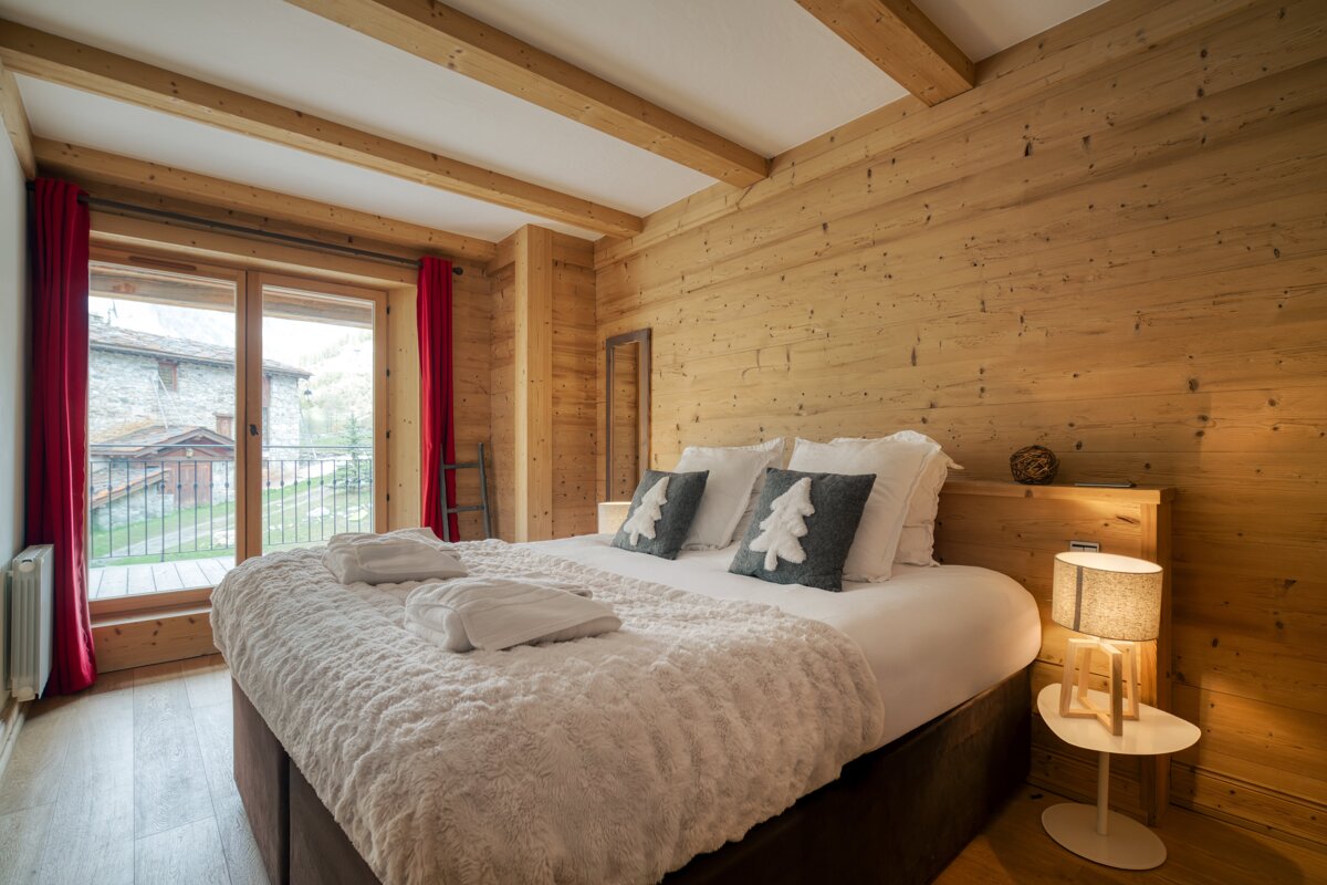 A bedroom with a king size bed and wooden walls