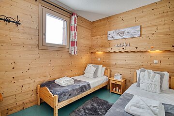A bedroom with two beds and a picture of a deer on the wall