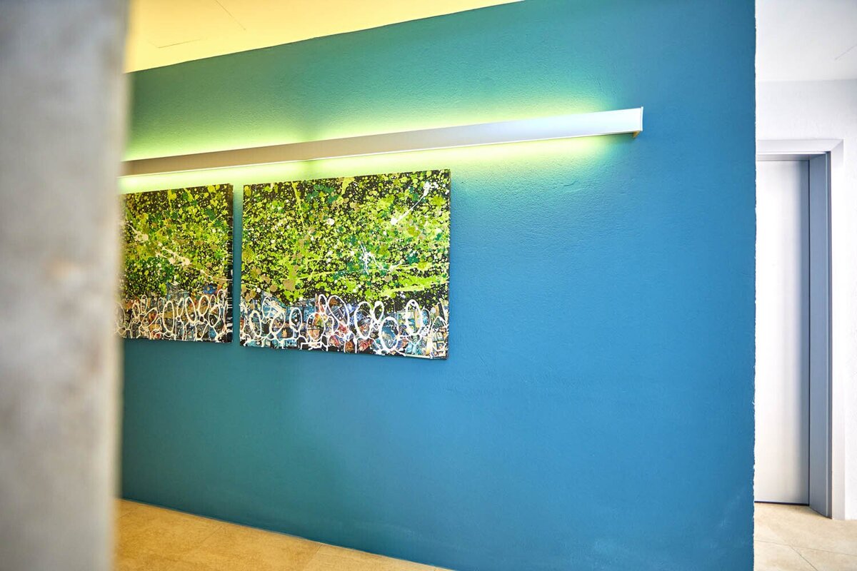 A blue wall with two paintings on it