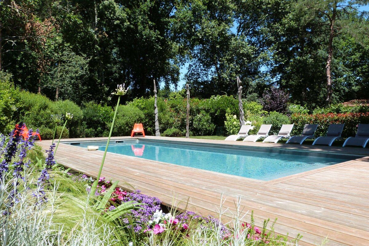 A large swimming pool surrounded by chairs and flowers