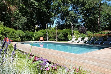 A large swimming pool surrounded by chairs and flowers